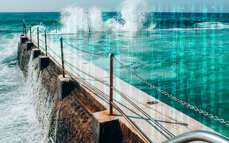 Computer code imposed over a photo of swimming pools at Sydney beach